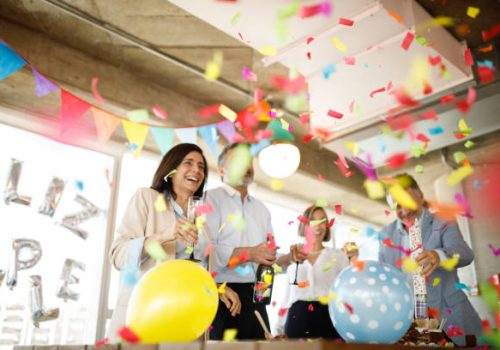 Coworkers celebrating birthday in office.